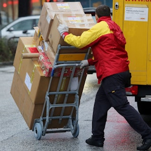 Unser Symbolbild zeigt einen Paketboten der Post, der am 24.12.2014 Päckchen in Hamburg ausliefert.