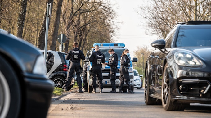 Polizeibeamtinnen und -beamte kontrollieren Autofahrer auf der Alfred-Schütte-Allee.&nbsp;