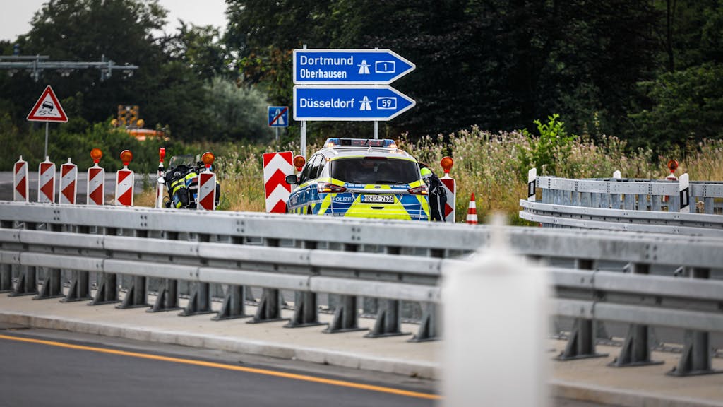 Ein Polizeiauto steht ans der Anschlussstelle Köln-Merkenich der A1.