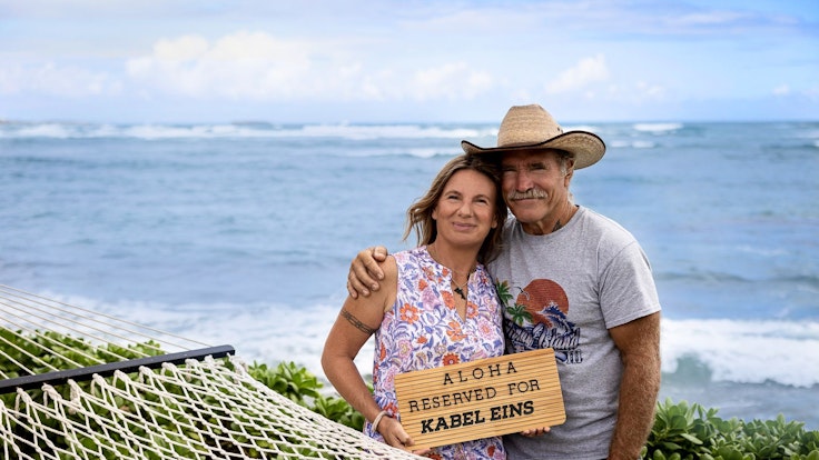 Die Kult-Auswanderer Manu und Konny Reimann wechseln posieren vor dem Meer für ein Foto.