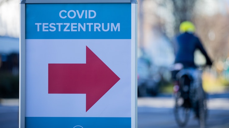 Ein Schild weist im Kölner Stadtzentrum den Weg zu einem Corona-Testzentrum.