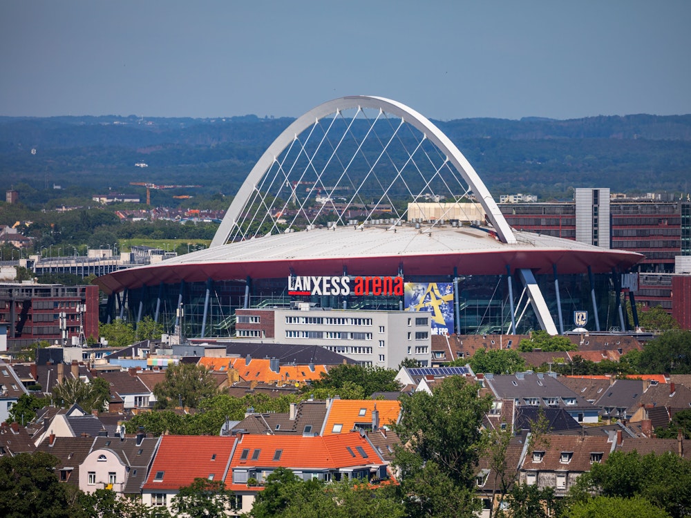 Die Lanxess-Arena, früher als Kölnarena bezeichnet, ist inmitten des Stadtteils Deutz zu sehen während der Blick bis weit in das Umland reicht.