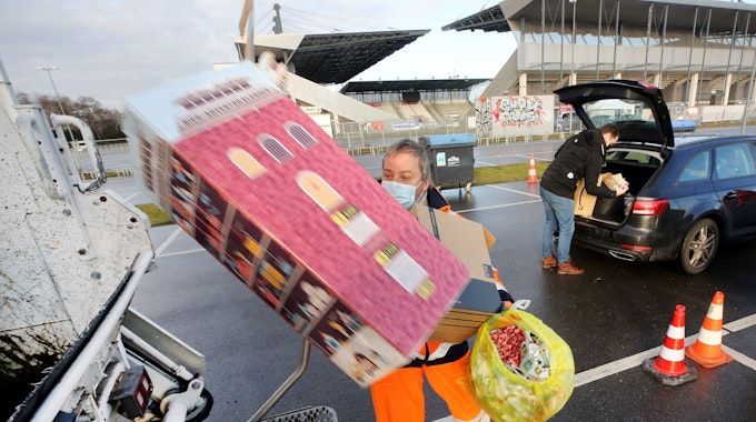 Geschenkpapier und -Kartons wirft ein Mitarbeiter der Entsorgungsbetriebe Essen in einen Müllwagen.&nbsp;