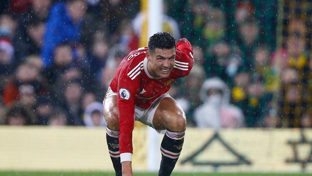 Cristiano Ronaldo hat ein schmerzverzerrtes Gesicht, geht in die Hocke und hält sich den Rücken.