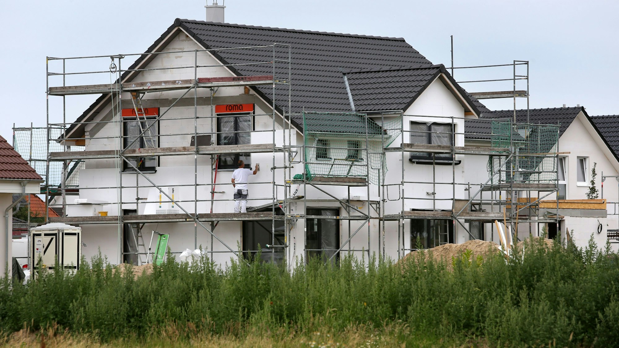 Bauarbeiter arbeiten 2015 an der Fertigstellung von Einfamilienhäusern.