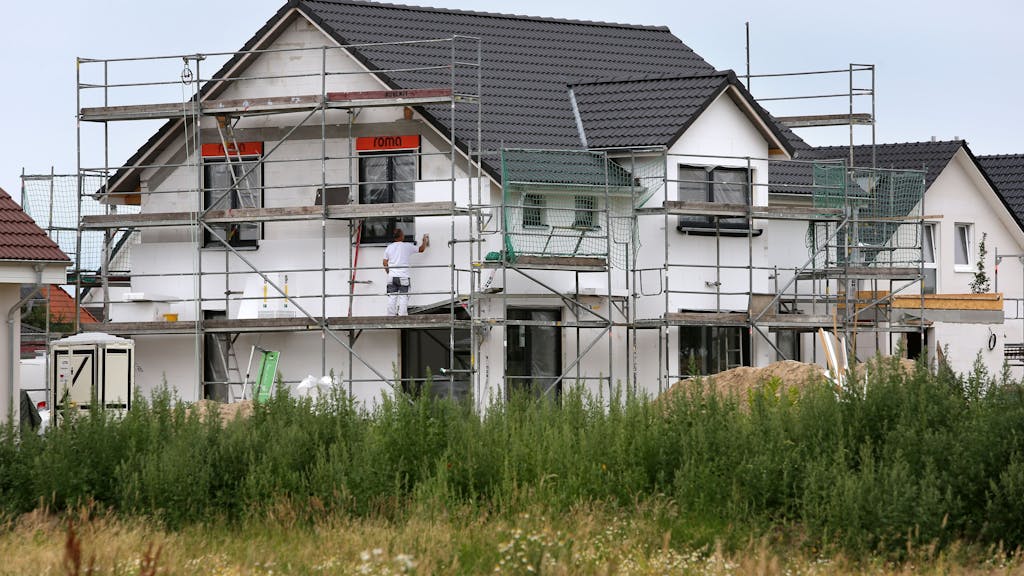 Bauarbeiter arbeiten 2015 an der Fertigstellung von Einfamilienhäusern.