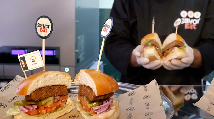 Ein Mitarbeiter präsentiert fertige Roboter-Burger.