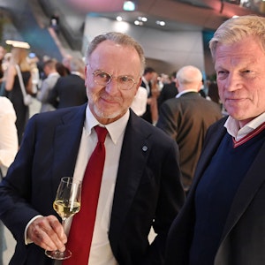 Karl-Heinz Rummenigge steht mit einem Glas Weißwein neben Oliver Kahn.