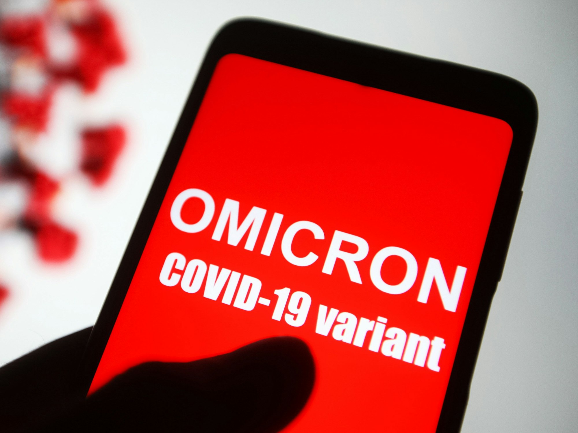 Auf dem Bildschirm eines Smartphones ist der Text „Omicron COVID-19-variant“ zu lesen.