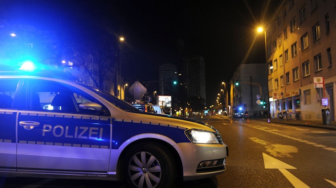 Ein Polizeiwagen mit Blaulicht auf einer Kölner Straße