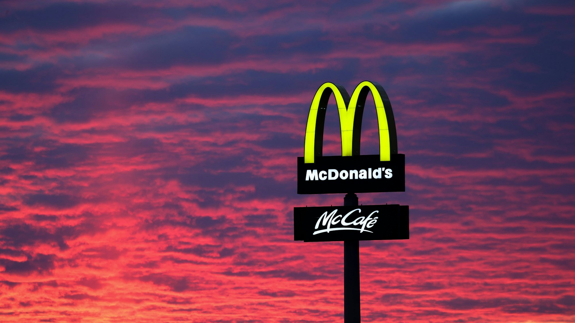 Der Abendhimmel leuchtet hinter einem McDonald's „M“.