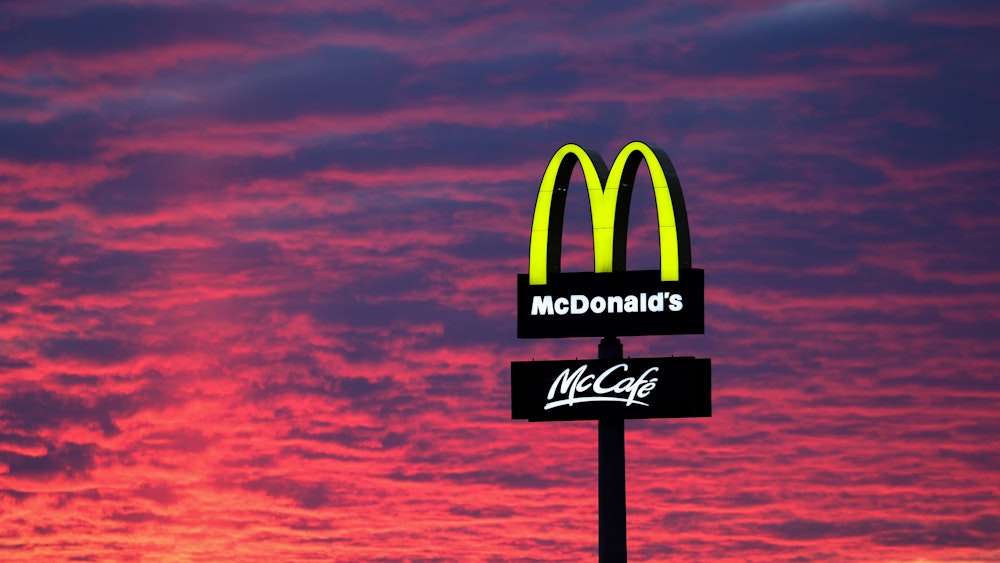 Der Abendhimmel leuchtet hinter einem McDonald's „M“.