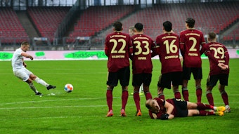 Der Kieler Lewis Holtby (l) schießt einen Freistoß in der Schlussphase des Spiels gegen Nürnberg.