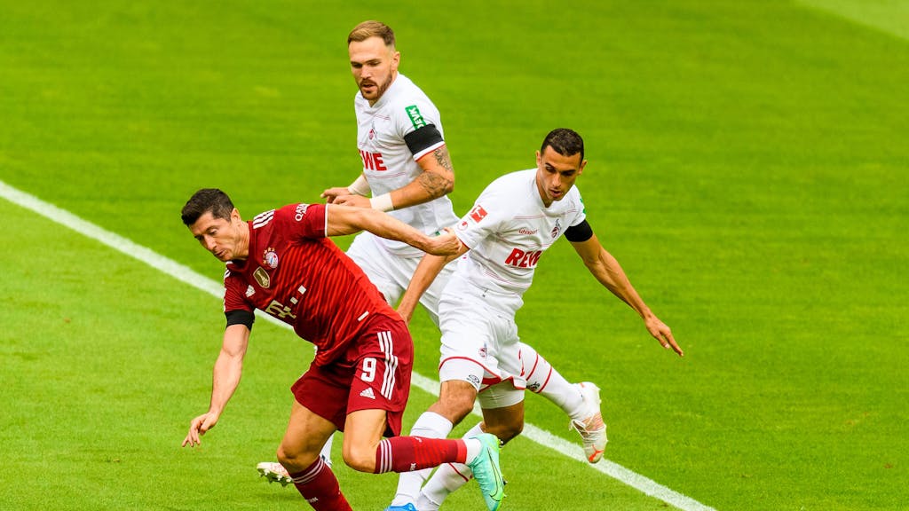 Ellyes Skhiri versucht Bayern-Stürmer Robert Lewandowski den Ball abzuluchsen, Rafael Czichos beobachtet den Zweikampf aus nächster Nähe.