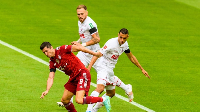 Ellyes Skhiri versucht Bayern-Stürmer Robert Lewandowski den Ball abzuluchsen, Rafael Czichos beobachtet den Zweikampf aus nächster Nähe.