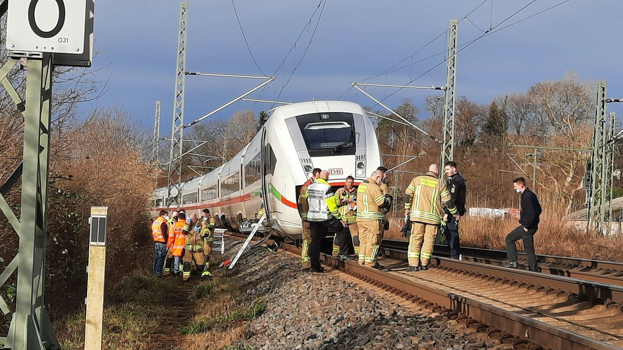 Ein ICE steht auf den Gleisen, davor und daneben Experten der Deutschen Bahn, die sich den Schaden an der Oberleitung angucken.