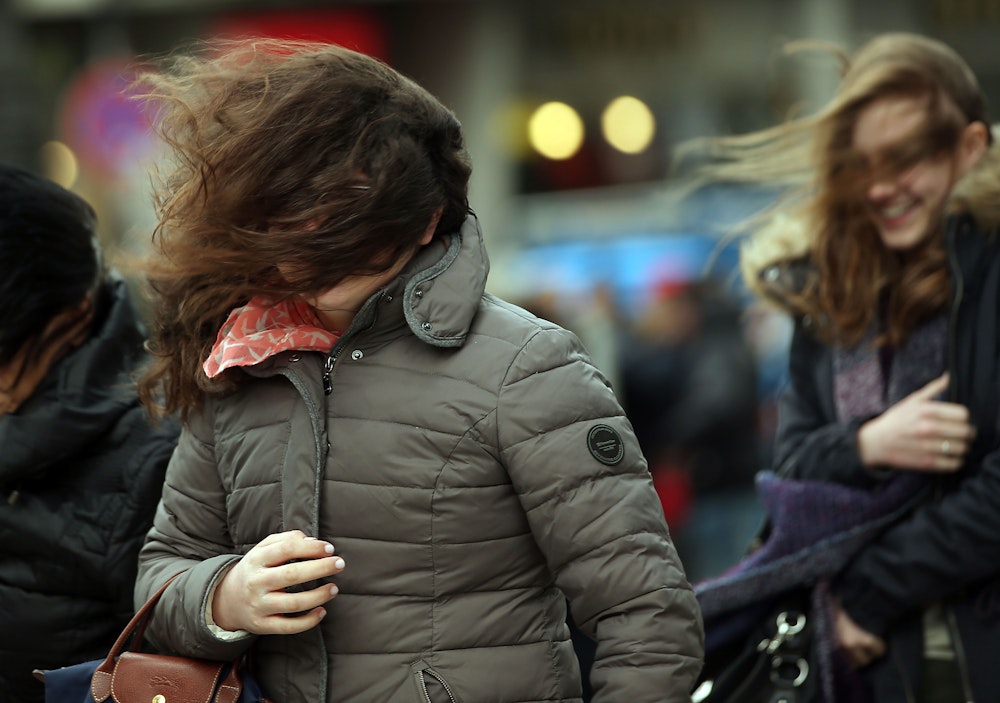 Mit durcheinandergewirbelten Haaren gehen am 31.03.2015 in Köln (Nordrhein-Westfalen) junge Frauen über die Domplatte.