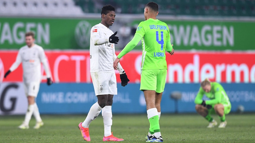 Gladbach-Stürmer Breel Embolo (l.) klatscht sich am 14. Februar 2021 nach dem torlosen Bundesliga-Duell beim VfL Wolfsburg fair mit Gegenspieler Maxence Lacroix (r.) ab.