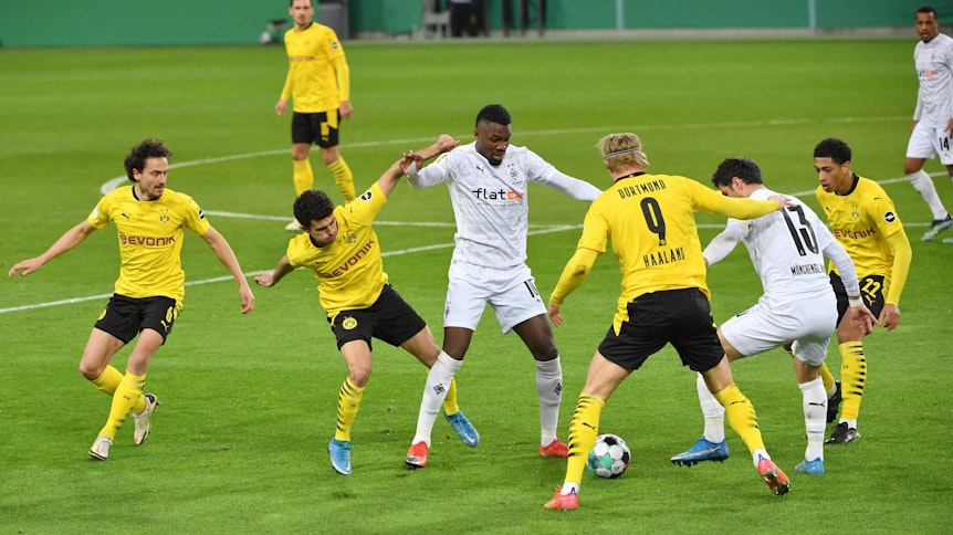 Gladbachs Profis Thuram (M.) und Stindl (r.) im Duell mit mehreren Dortmunder Spielern im Pokal-Viertelfinale (2. März 2021).