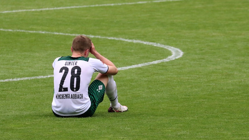 Gladbachs Matthias Ginter sitzt nach dem 1:2 gegen Stuttgart am 15. Mai 2021 enttäuscht auf dem Rasen im Borussia-Park.