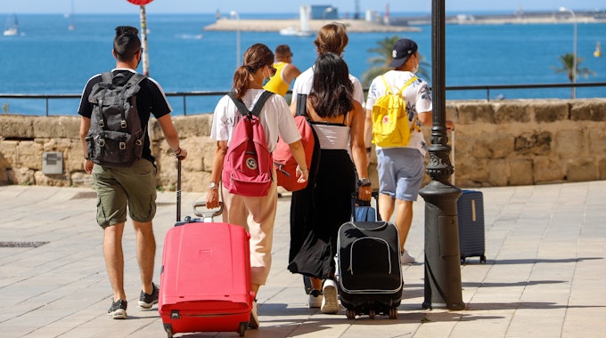 Touristen gehen im Juni 2021 mit ihren Rollkoffern durch die Urlaubsinsel Mallorca.