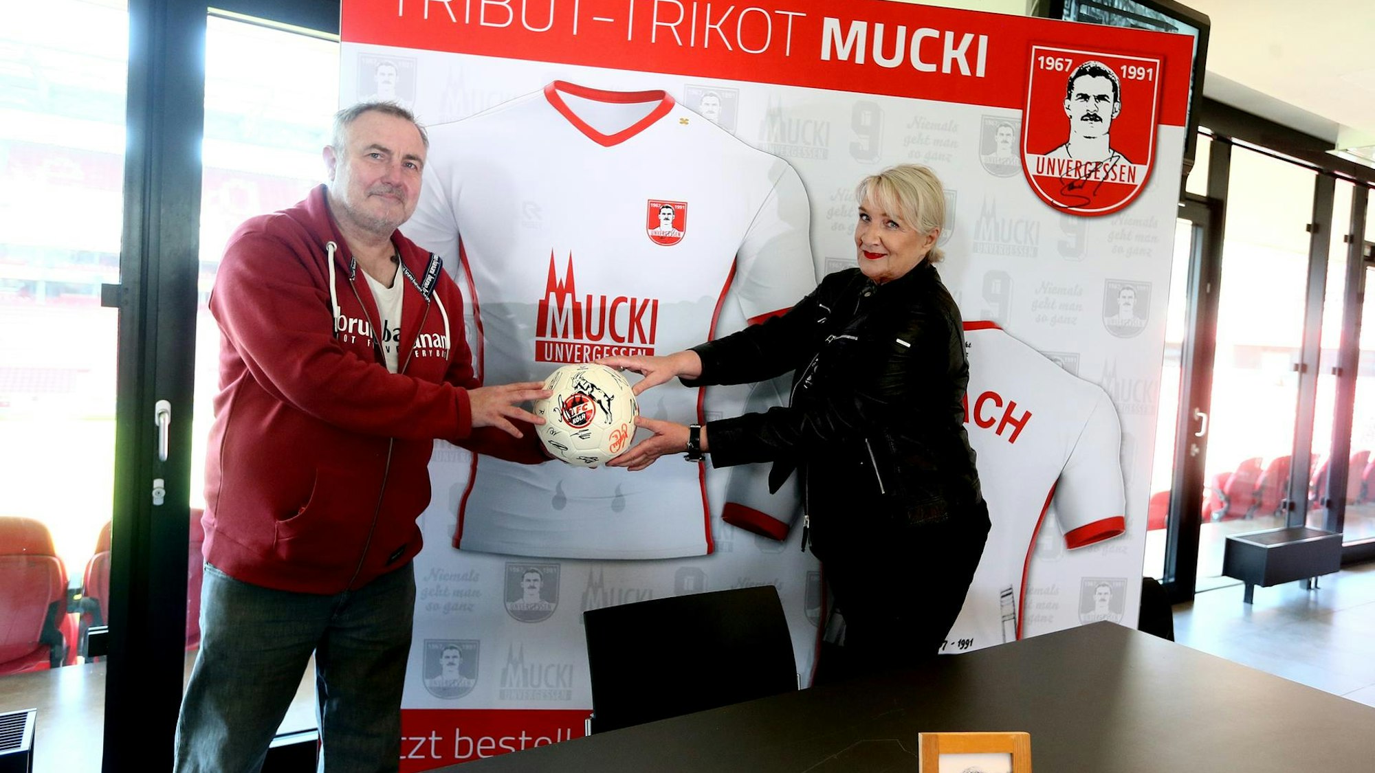 Andreas Gielchen und Claudia Banach halten einen FC-Ball