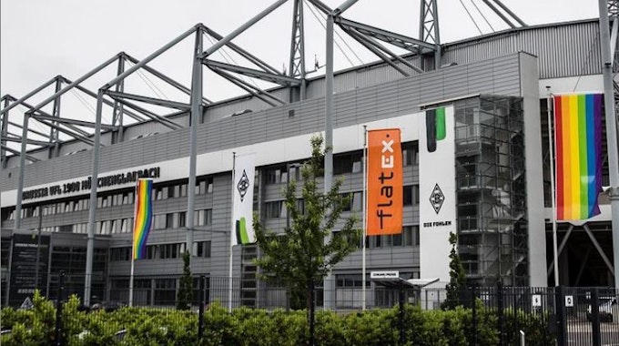 Der Gladbacher Borussia-Park mit gehissten Regenbogenfahnen an den Masten am 23. Juni 2021.