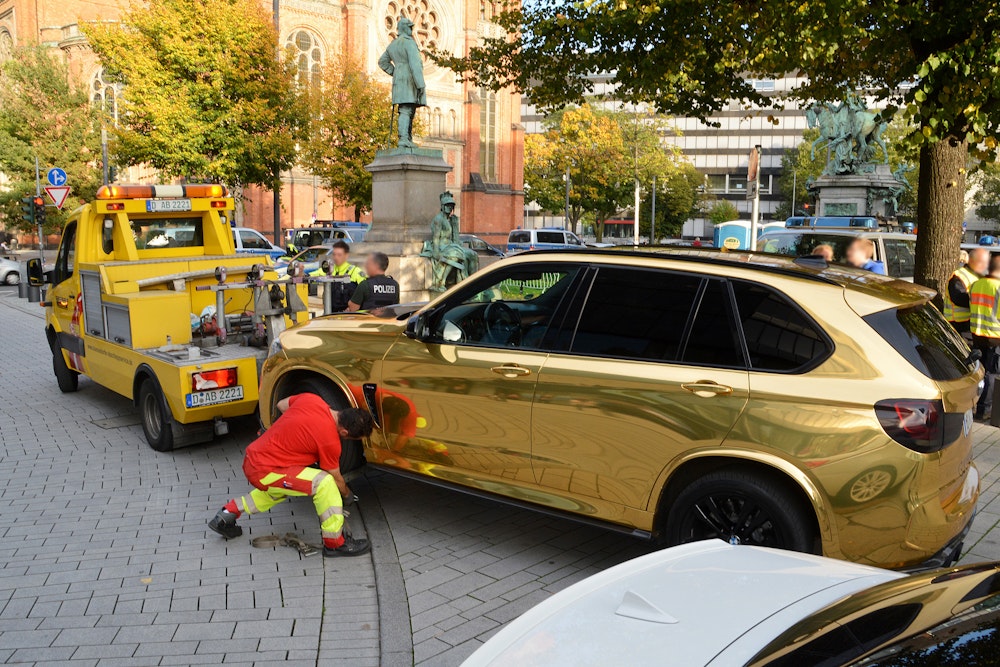 Ein goldener BMW wird nahe der Königsallee in Düsseldorf 2019 abgeschleppt.