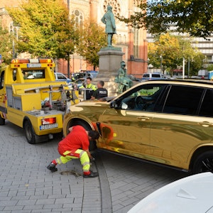Ein goldener BMW wird nahe der Königsallee in Düsseldorf 2019 abgeschleppt.