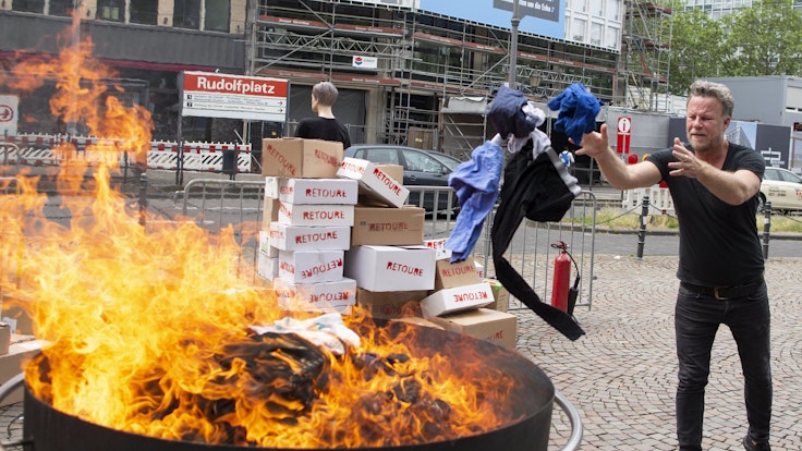 Jenke von Wilmsdorff wirft Klamotten in ein Feuer in Köln. Foto von der dpa, honorarfrei