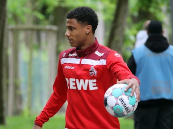 Ismail Jakobs (1. FC Köln) trägt einen Ball zum Training des 1. FC Köln.