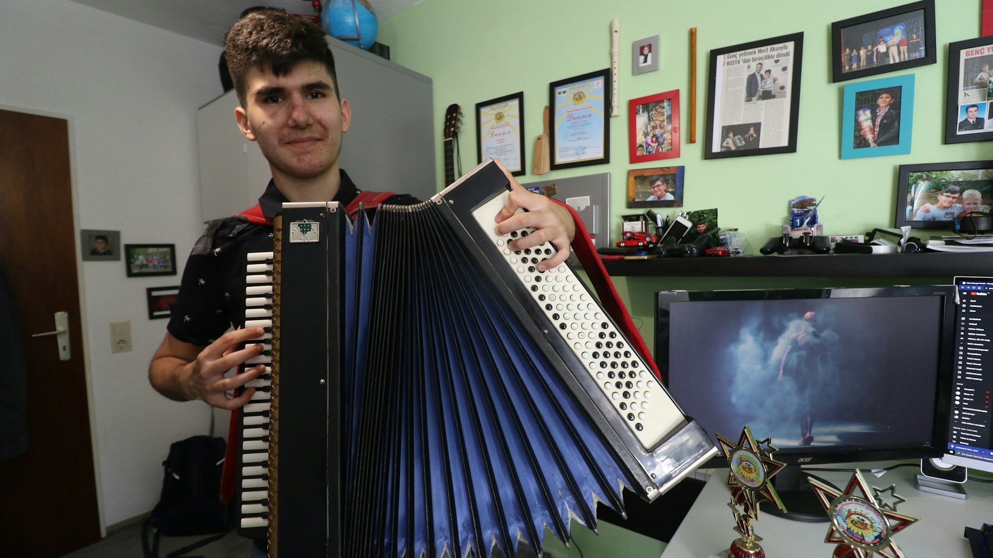 Der Kölner Akkordeonist Mert Aksoylu (15) steht ins einem Zimmer. Er gewann vor wenigen Tagen seinen dritten internationalen Musikwettbewerb.