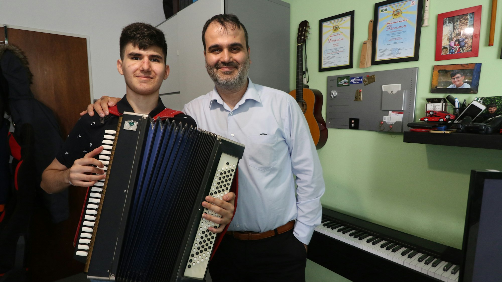 Der Kölner Akkordeonist mert Aksoylu (15) gewann vor wenigen Tagen seinen dritten internationalen Musikwettbewerb. Hier in seinem Zimmer am in Köln-Sammheim mit seinem Vater Isa.