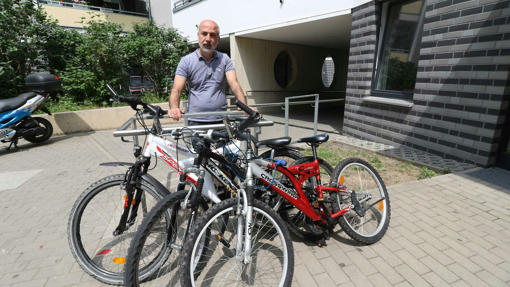 Yilmaz Özkul steht neben den Fahrrädern, die er beim Fundbüro der Stadt Köln gekauft hatte.