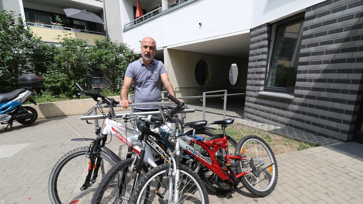 Yilmaz Özkul steht neben den Fahrrädern, die er beim Fundbüro der Stadt Köln gekauft hatte.