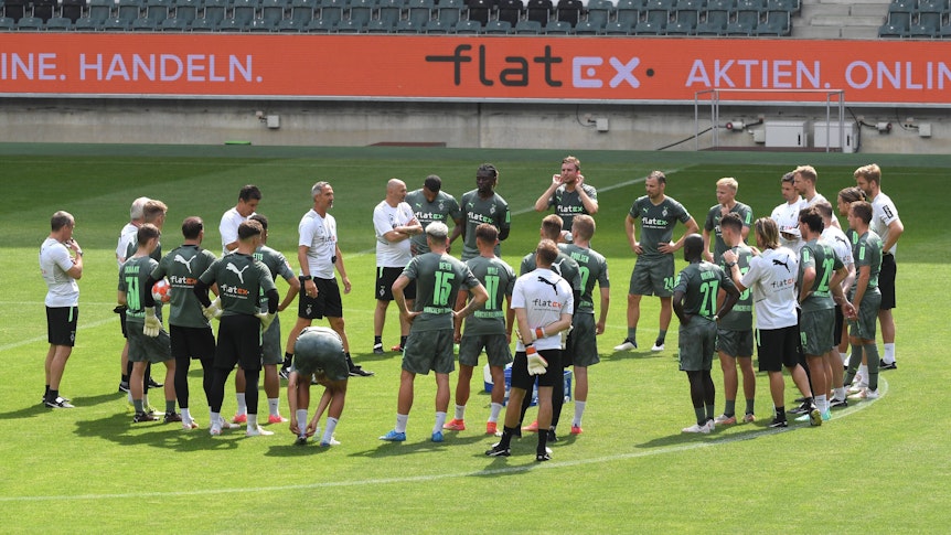 Kreisförmig hat sich die Gladbacher Mannschaft um Neu-Trainer Adi Hütter auf dem grünen Rasen des Borussia-Parks versammelt.