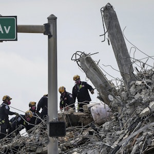 Rettungskräfte suchen in den Trümmern des Wohnkomplexes nach Überlebenden.