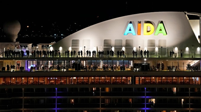 Menschen stehen auf dem Deck des deutschen Kreuzfahrtschiffs Aida Nova, das am Freitag kurz vor Mitternacht in Lissabon angelegt hat.