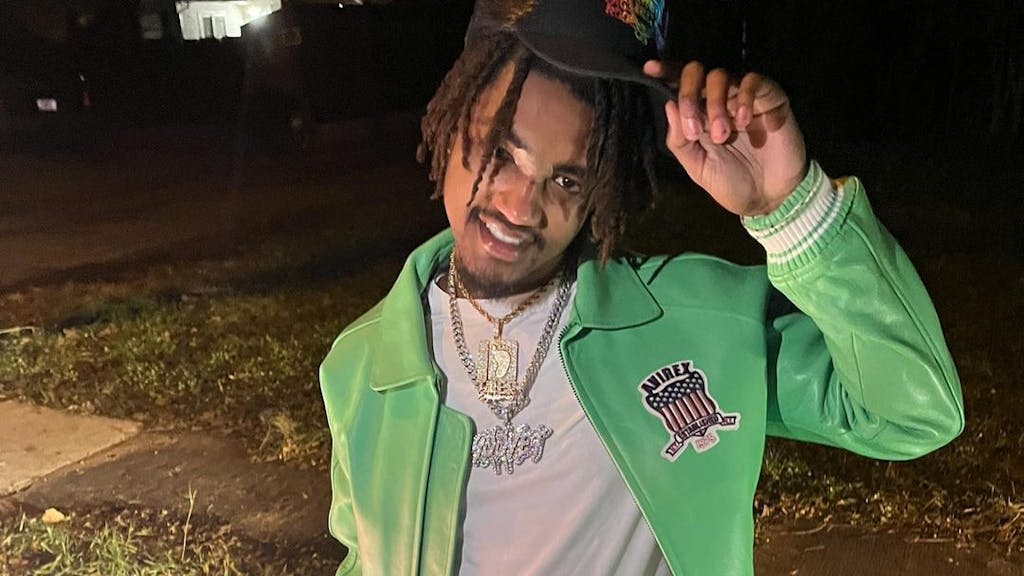 Rapper Lil Devin, hier auf einem Instagram-Foto, posiert mit Kappe und grünem Sweater. 