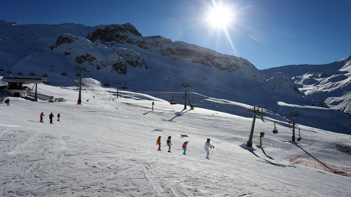 Mehrere Skifahrer fahren eine schneebedeckte Piste herab.&nbsp;