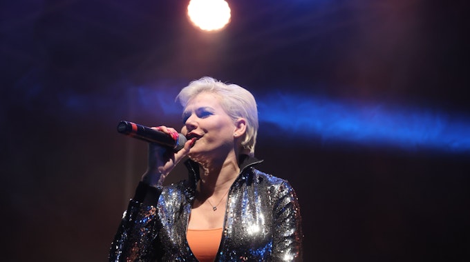 Schlagersängerin Melanie Müller singt auf der Bühne bei einer Autodisco.