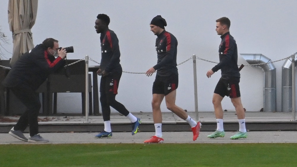 Die Bayern-Spieler Alphonso Davies, Leon Goretzka und Joshua Kimmich gehen zum Training.