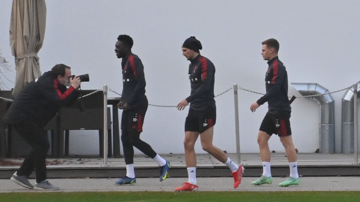 Die Bayern-Spieler Alphonso Davies, Leon Goretzka und Joshua Kimmich gehen zum Training.