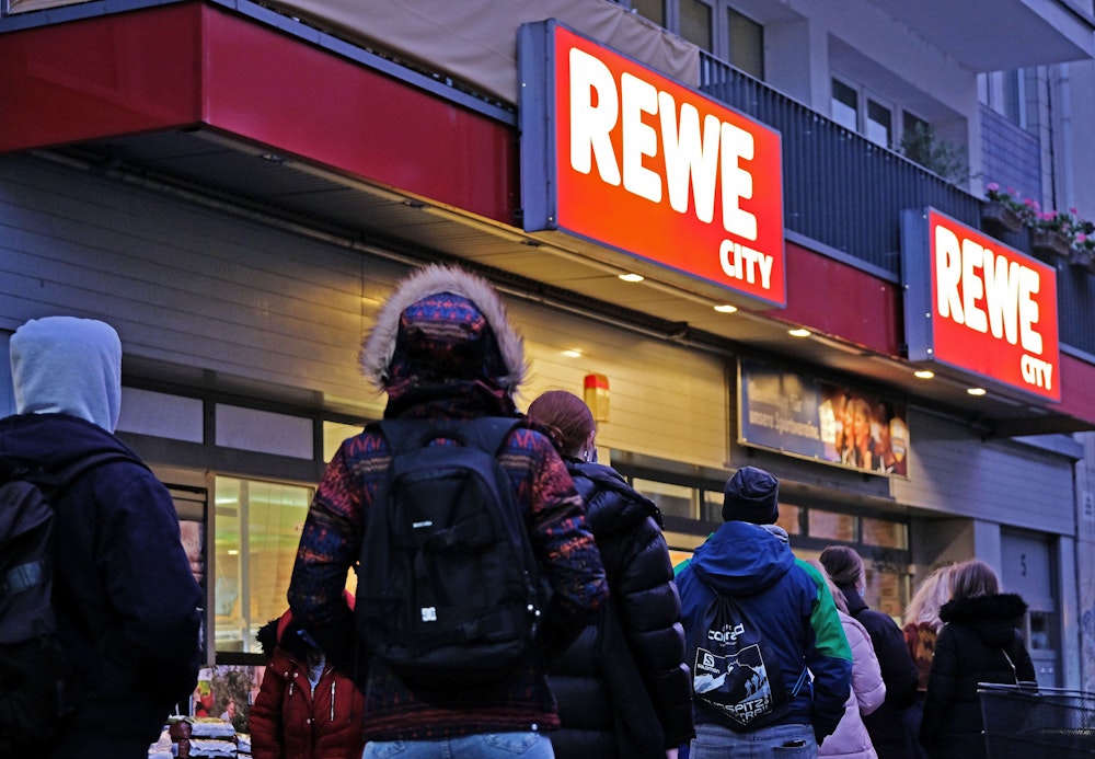 Menschen stehen im November 2020 vor einem Rewe-Supermarkt in einer Schlange an: Auch im Zuge der Corona-Pandemie liegt Deutschland im Online-Lebensmittelhandel massiv zurück.