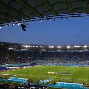 Das Stadioninnere ist aus dem Weitwinkel zu sehen. Die Mannschaft stehen auf dem Platz und lauschen den Nationalhymnen.