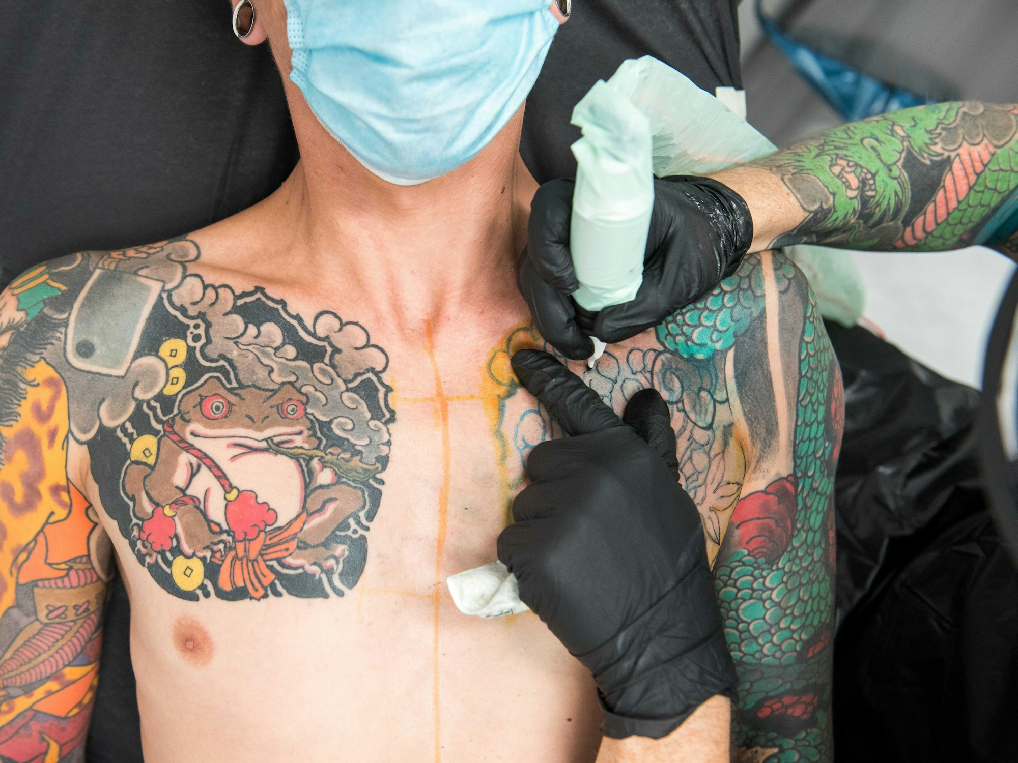 Ein Mann wird im Tattoostudio der Firma Edding tätowiert.