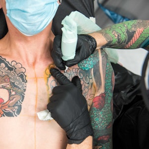 Ein Mann wird im Tattoostudio der Firma Edding tätowiert.