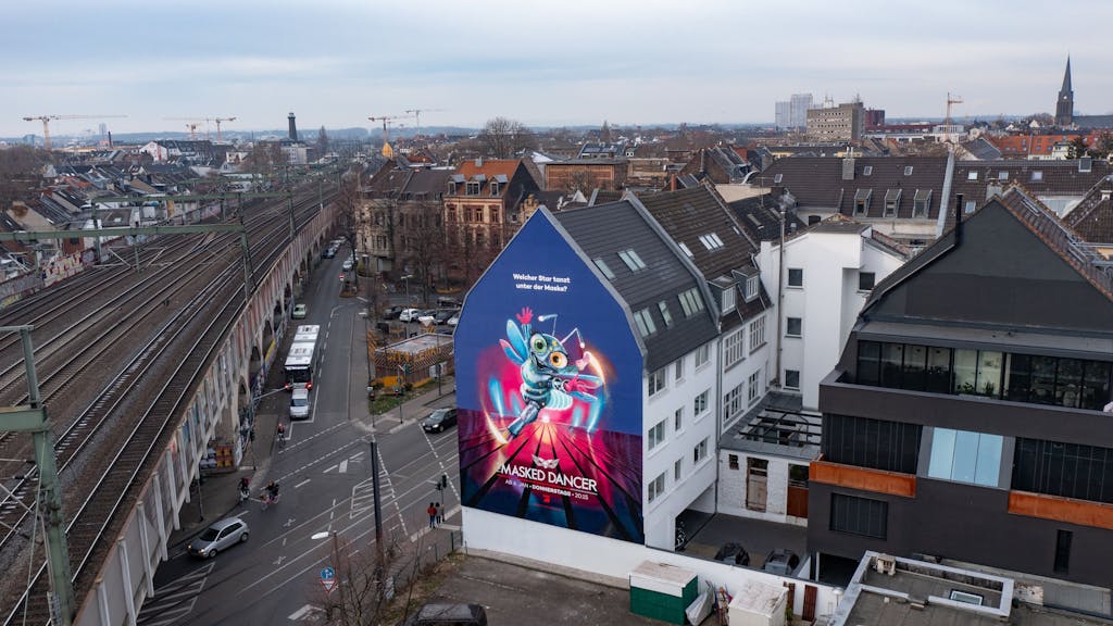 The Masked Dancer-Werbung auf Hausfassade in Köln-Ehrenfeld.