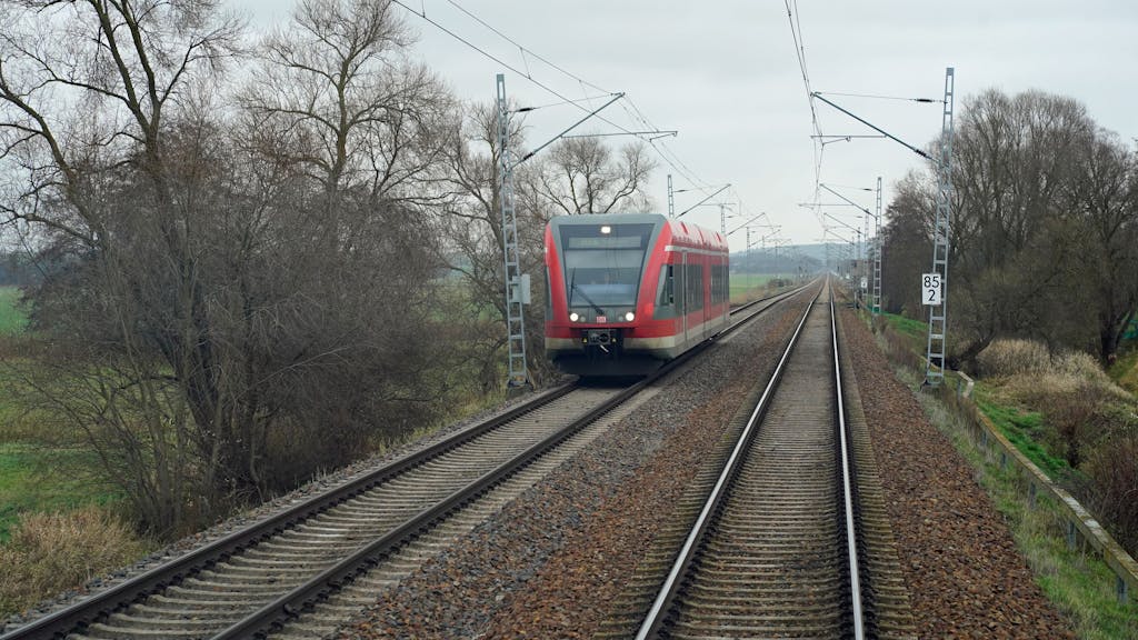 Auf dem Foto sieht man einen Zug der Deutschen Bahn, der eine Strecke abfährt.