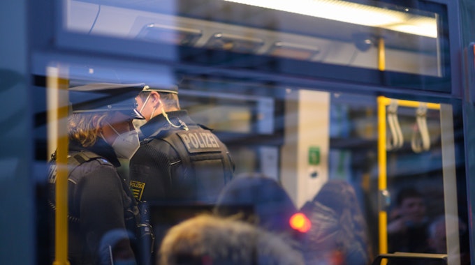 Polizisten fahren Ende November in der Dresdner Innenstadt in einer Straßenbahn mit. Je höher die Corona-Infektionszahlen steigen, desto schwieriger wird es auch, wichtige Versorgungsbereiche personell zu besetzen.